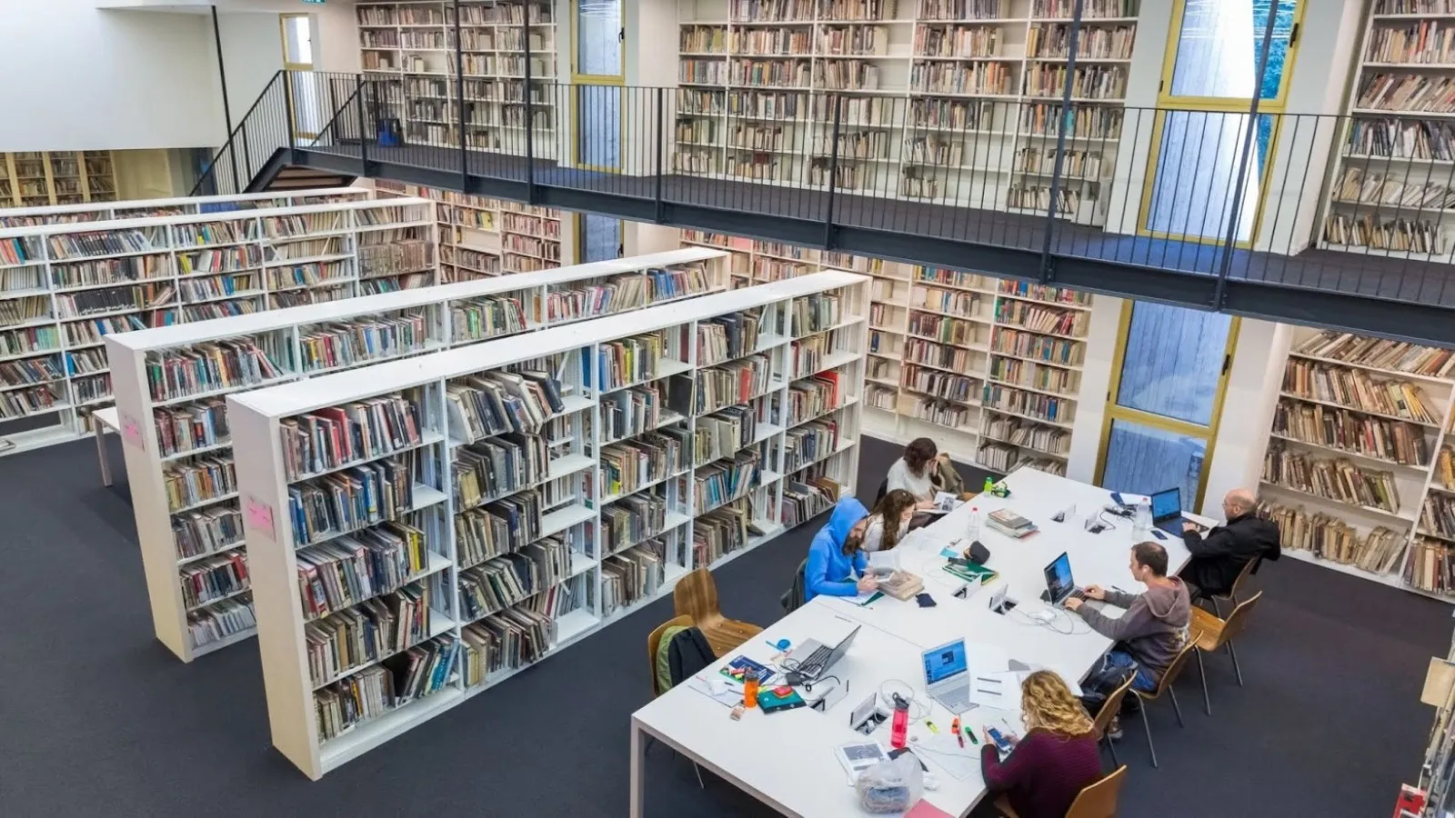 אנשים לומדים ליד שולחן קריאה בספרייה